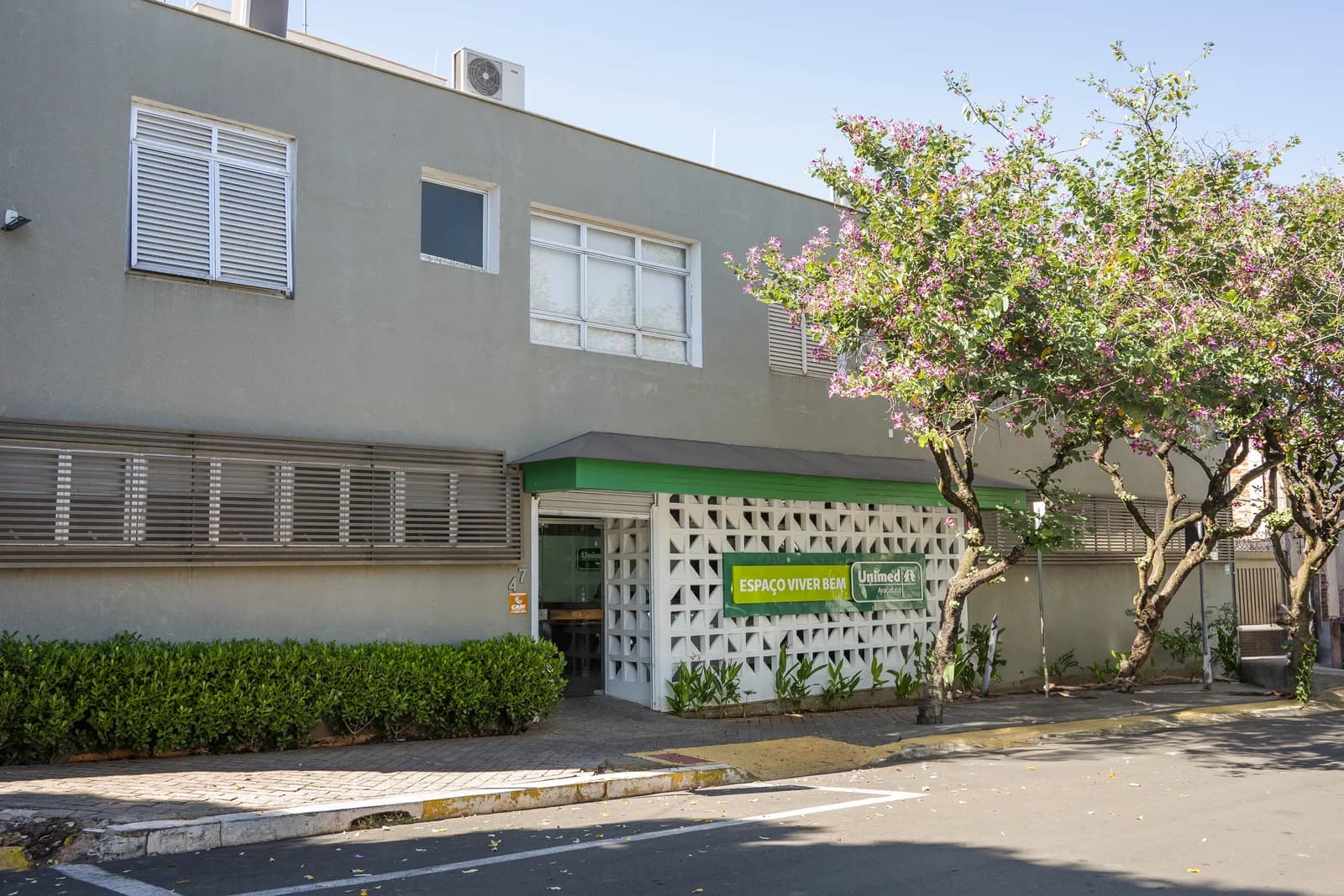 Fachada do Espaço Viver Bem, com a placa da unidade e o muro de cobogó